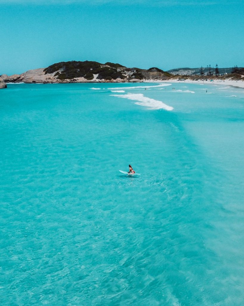 A lone paddleboarder on the crystal-clear turquoise waters of Twilight Bay, surrounded by pristine white sand beaches in Esperance, Western Australia.