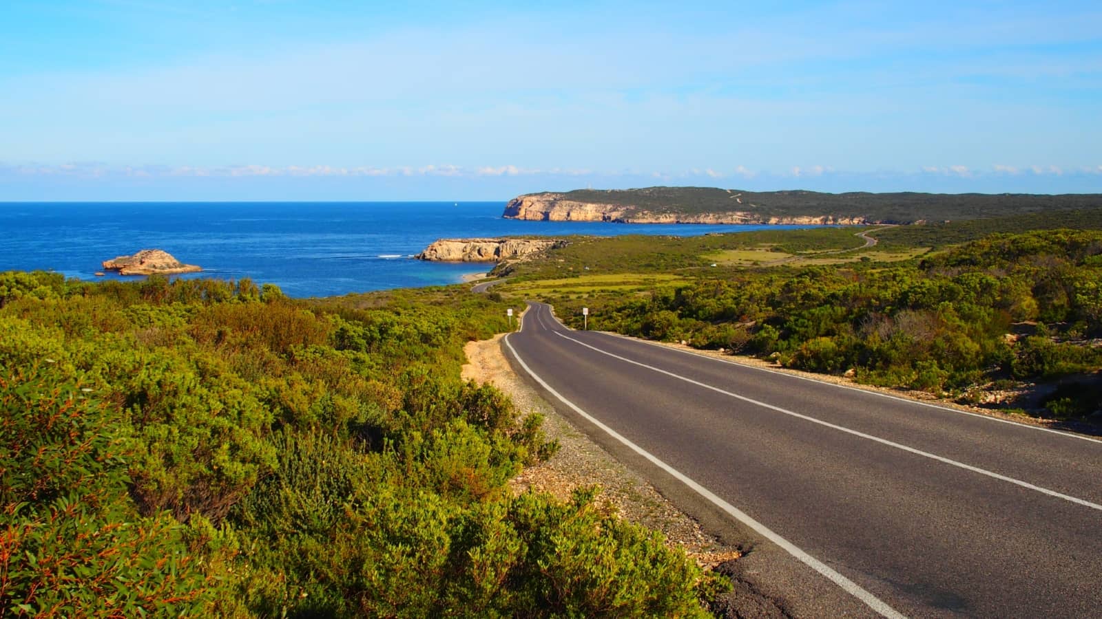 A winding coastal road framed by native scrub, with sweeping views of cliffs and the sea near Marion Bay on a Yorke Peninsula road trip.