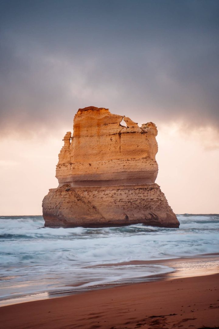 Dramatic view of the Gibson Steps rock formation at sunset, with golden light and waves crashing below, along the Great Ocean Road on a Melbourne to Perth road trip.