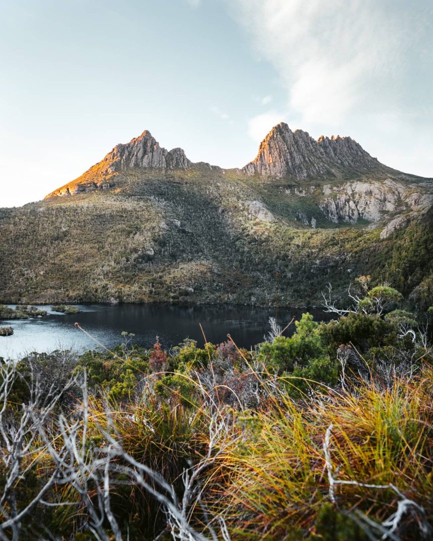 Scenic view of Cradle Mountain, with golden light hitting the peaks above Dove Lake, a popular stop during a 7 day Tasmania road trip.