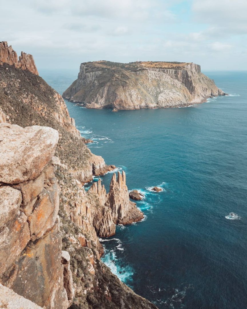Towering cliffs and rugged sea stacks viewed from Cape Raoul with Tasman Island in the distance on the great eastern drive.