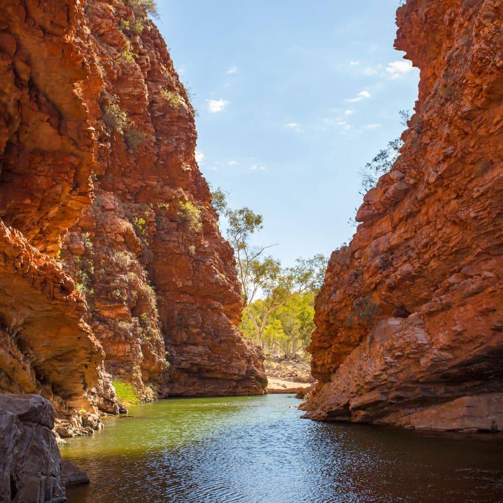 A gap between two big rock formations, filled with water. One of the things to do in Alice Springs for free. This is the popular Simpsons Gap in Alice Springs.