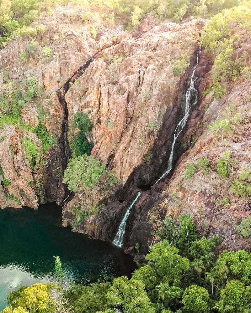 Wangi Falls in Litchfield National Park, falling from a rocky surface down a rock pool surrounded by forest