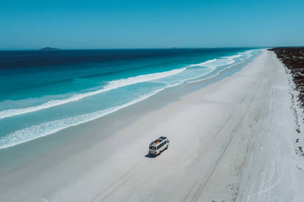 Salt and Charcoal bus driving along Le Grand Beach in Esperance, Western Australia