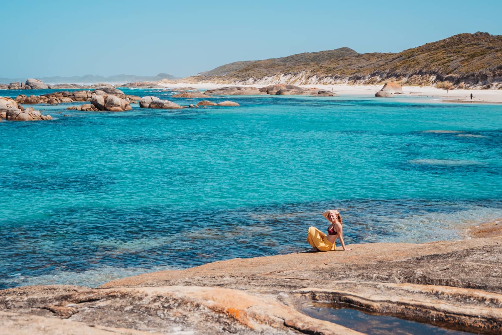 A woman at a turquoise beach with rock formations in Denmark Western Australia