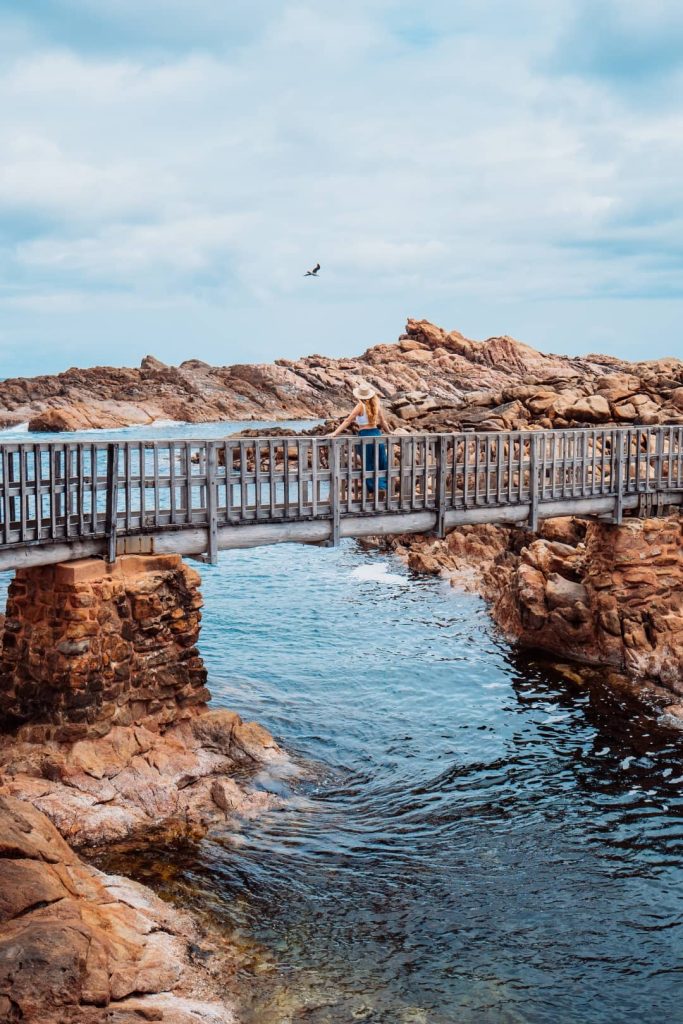 A woman on the bridge enjoying the scenic view at the Canal Rocks Margaret River, Western Australia