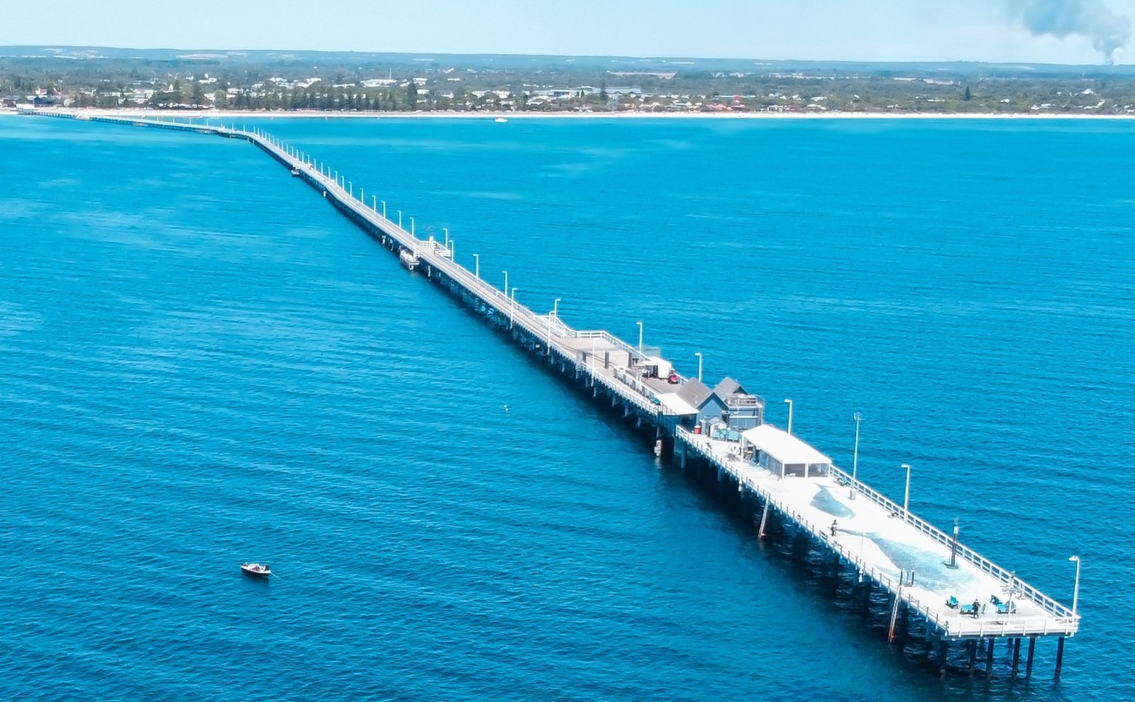 The iconic Busselton Jetty stretches into the turquoise waters of the Indian Ocean, a landmark pier known as the longest wooden jetty in the world, located in the coastal town of Busselton, Western Australia.