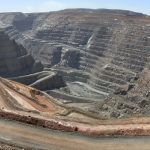 An aerial view of the expansive Super Pit gold mine in Kalgoorlie, Western Australia, with terraced walls and deep trenches.