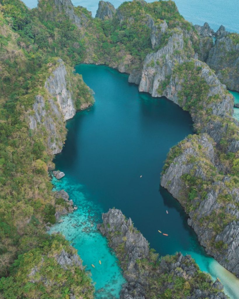 Another aerial perspective of Big Lagoon in El Nido, Palawan, surrounded by towering limestone formations and crystal-clear turquoise water. A must-visit place to explore in the Philippines for nature lovers and adventurers.