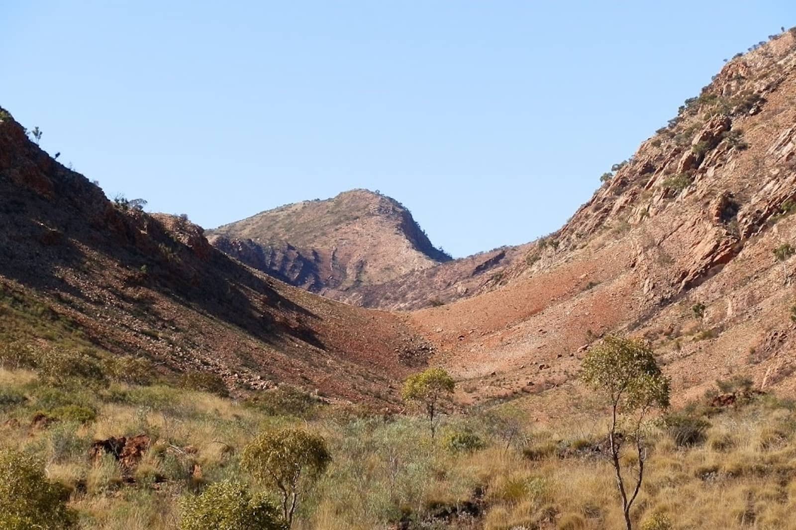 Rocky gorge surrounded by grassy hills on the Ormiston Gorge and Pound Walk, a top activity when exploring things to do in Central Australia.