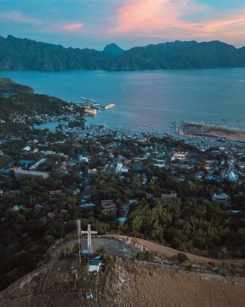 Drone shot overlooking the town of Coron and Mount Tapyas viewpoint at sunset, one of the top land-based things to do in Coron, Philippines.