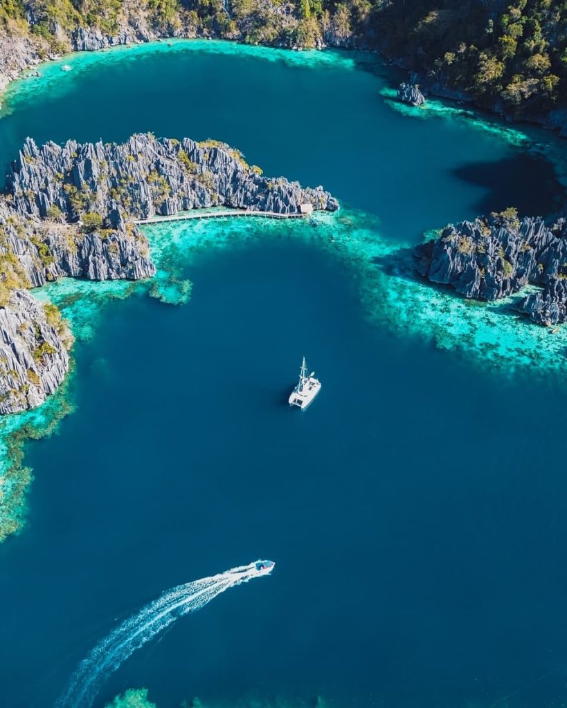  Drone shot of boats in the deep blue Twin Lagoon, one of the must-do things to do in Coron, Philippines.