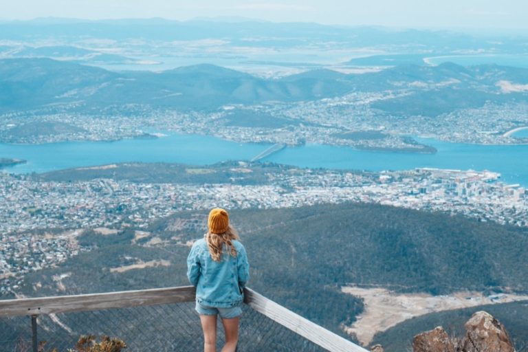 A woman stands at a lookout on Mount Wellington, gazing over Hobart and the Derwent River, one of the best things to do in Hobart.